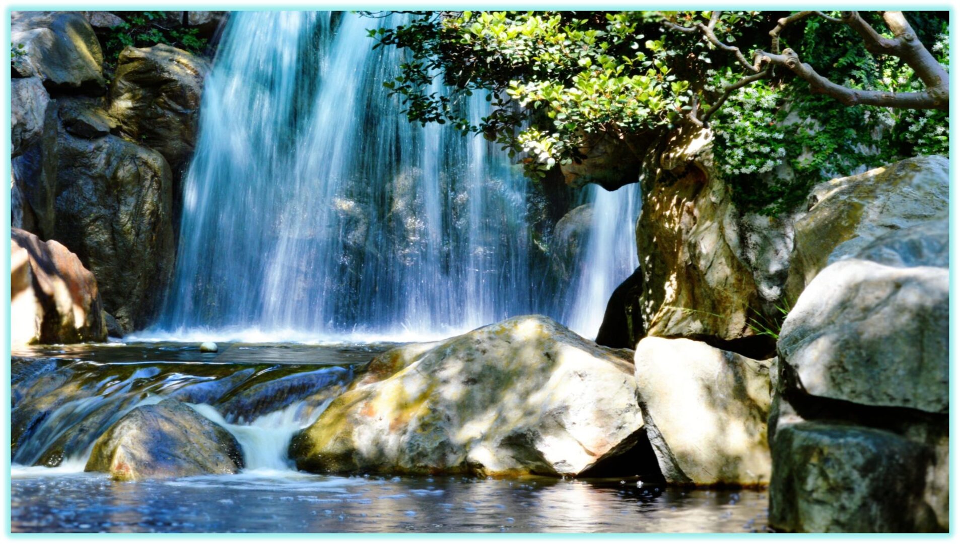 A serene waterfall cascading over rocks surrounded by greenery.